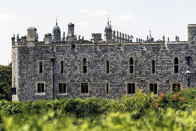 Reihen schlanker Zinnen und Endspitzen krönen die Reihe der State Apartments aus Feuerstein und Stein in Windsor Castle, die über eine Gartenbepflanzung hinweg zu sehen sind und die kunstvolle gotische Silhouette veranschaulichen, die dem Gebäude während seines Umbaus im 19. Jahrhundert verliehen wurde, Windsor, England, Großbritannien Rows of slender pinnacles and finials crown the flint and stone State Apartments range at Windsor Castle, seen across garden planting, illustrating the elaborate Gothic silhouette given to the building during its nineteenth century remodelling, Windsor, England, United Kingdom Copyright: imageBROKER DavidxRowland iblbmv18821770.jpg