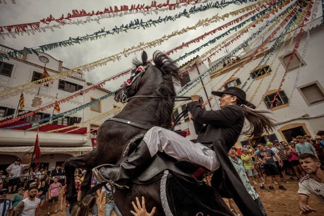 August 24, 2026, Ferreries, Menorca Balearic Islands, Spain: A caixer, or horse rider, rears his horse amid a cheering crowd during the traditional Jaleo at the Sant Bartomeu Festival in Ferreries. Ferreries Spain  - ZUMAo105 20260824_fap_o105_006 Copyright: xMatthiasxOesterlex