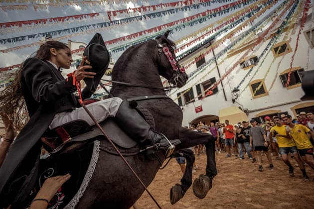 August 24, 2026, Ferreries, Menorca Balearic Islands, Spain: A caixer, or horse rider, rears his horse amid a cheering crowd during the traditional Jaleo at the Sant Bartomeu Festival in Ferreries. Ferreries Spain  - ZUMAo105 20260824_fap_o105_016 Copyright: xMatthiasxOesterlex
