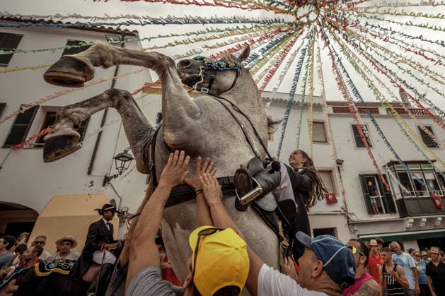 August 24, 2026, Ferreries, Menorca Balearic Islands, Spain: A caixer, or horse rider, rears his horse amid a cheering crowd during the traditional Jaleo at the Sant Bartomeu Festival in Ferreries. Ferreries Spain - ZUMAo105 20260824_fap_o105_010 Copyright: xMatthiasxOesterlex
