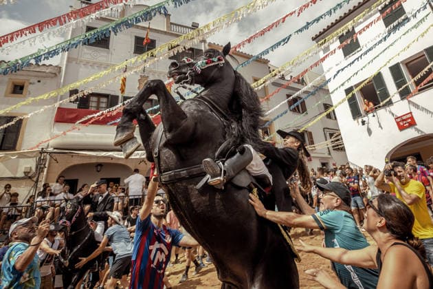 August 24, 2026, Ferreries, Menorca Balearic Islands, Spain: A caixer, or horse rider, rears his horse amid a cheering crowd during the traditional Jaleo at the Sant Bartomeu Festival in Ferreries. Ferreries Spain  - ZUMAo105 20260824_fap_o105_027 Copyright: xMatthiasxOesterlex