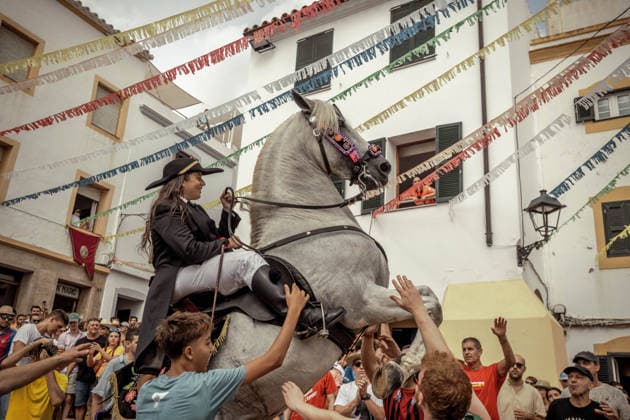 August 24, 2026, Ferreries, Menorca Balearic Islands, Spain: A caixer, or horse rider, rears his horse amid a cheering crowd during the traditional Jaleo at the Sant Bartomeu Festival in Ferreries. Ferreries Spain  - ZUMAo105 20260824_fap_o105_029 Copyright: xMatthiasxOesterlex