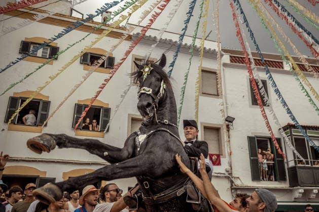 August 24, 2026, Ferreries, Menorca Balearic Islands, Spain: A caixer, or horse rider, rears his horse amid a cheering crowd during the traditional Jaleo at the Sant Bartomeu Festival in Ferreries. Ferreries Spain  - ZUMAo105 20260824_fap_o105_031 Copyright: xMatthiasxOesterlex
