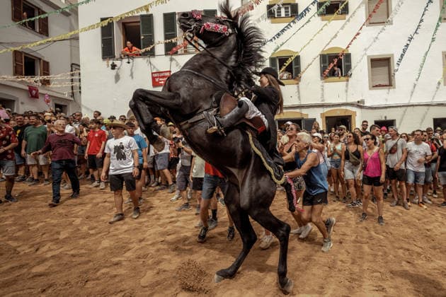 August 24, 2026, Ferreries, Menorca Balearic Islands, Spain: A caixer, or horse rider, rears his horse amid a cheering crowd during the traditional Jaleo at the Sant Bartomeu Festival in Ferreries. Ferreries Spain  - ZUMAo105 20260824_fap_o105_035 Copyright: xMatthiasxOesterlex