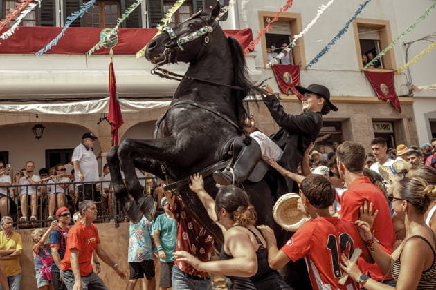 August 24, 2026, Ferreries, Menorca Balearic Islands, Spain: A caixer, or horse rider, rears his horse amid a cheering crowd during the traditional Jaleo at the Sant Bartomeu Festival in Ferreries. Ferreries Spain  - ZUMAo105 20260824_fap_o105_033 Copyright: xMatthiasxOesterlex