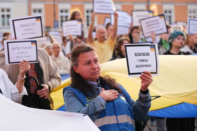August 24, 2026, Warsaw, Masovian Voivodeship, Poland: People hold up placards with the names of Ukrainians killed in Russian attacks as others hold giant Ukrainian and Polish flags during celebrations of Ukraine s 35th Independence Day in Warsaw, Poland. The event was organized by Ukrainian diaspora organizations and Polish activist groups in solidarity with Ukraine during a time of heightened tensions between Poles and Ukrainian migrants, with recent acts of xenophobic, anti-Ukrainian violence being incited by Polish far-right groups and politicians. Warsaw Poland - ZUMAk204 20260824_zip_k204_001 Copyright: xRomanxKozielx