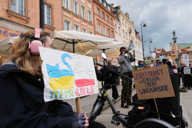 August 24, 2026, Warsaw, Masovian Voivodeship, Poland: Polish antifascist groups protest against a far-right, anti-Ukrainian counter-demonstration during celebrations of Ukraine s 35th Independence Day in Warsaw, Poland. The event was organized by Ukrainian diaspora organizations and Polish activist groups in solidarity with Ukraine during a time of heightened tensions between Poles and Ukrainian migrants, with recent acts of xenophobic, anti-Ukrainian violence being incited by Polish far-right groups and politicians. The protester holds a sign that reads friends written half in Polish and half in Ukrainian while to the right is a sign that reads lesbians and trans persons support Ukrainians. Warsaw Poland - ZUMAk204 20260824_zip_k204_035 Copyright: xRomanxKozielx