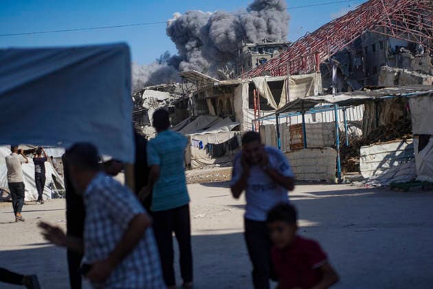 Water Desalination Plant Strike Gaza City Palestinians stand, some covering their ears, in a street as smoke rises from a destroyed water desalination plant in the Sheikh Radwan neighborhood in Gaza City, Gaza Strip, on August 24, 2026. The facility was targeted after an Israeli army officer called a local resident to issue an evacuation warning for the area near the Ahli Club, resulting in no reported casualties. Gaza Gaza Strip Palestinian Territories Copyright: xMohammedxAlxQumsanx