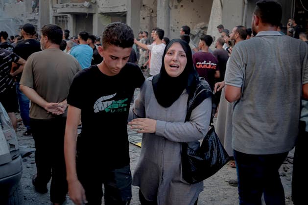 Israeli Strikes Beach Camp Gaza City A Palestinian woman and a young man walk through a crowd in a rubble-strewn street at the site of an Israeli strike in Gaza City, Gaza Strip, on August 24, 2026. Israeli warplanes struck the site following an evacuation warning to residents, completely destroying the Asqalan Prayer Hall and reportedly damaging nearby buildings. Gaza Gaza Strip Palestine Territories Copyright: xMohammedxMxSkaikx