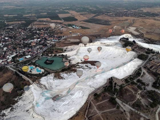 (260825) -- DENIZLI, Aug. 25, 2026 -- An aerial drone photo taken on Aug. 25, 2026 shows hot air balloons fly over Pamukkale in Denizli, T¨¹rkiye. ( Handout via Xinhua) T?RKIYE-DENIZLI-HOT AIR BALLOONS MustafaxKaya 