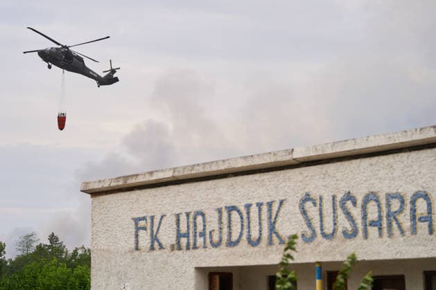 August 25, 2026, Susara, Vojvodina, Serbia: 2026825, Susara, Serbia - Two Sikorsky UH-60 Black Hawk helicopters are deployed to the village of Susara to help battle the severe wildfires devastating the Deliblato Sands (Deliblatska Pescara) Special Nature Reserve, refilling their buckets from a large portable water tank placed on a local football pitch. Susara Serbia  - ZUMAd223 20260825_zip_d223_003 Copyright: xMarkoxDimicx