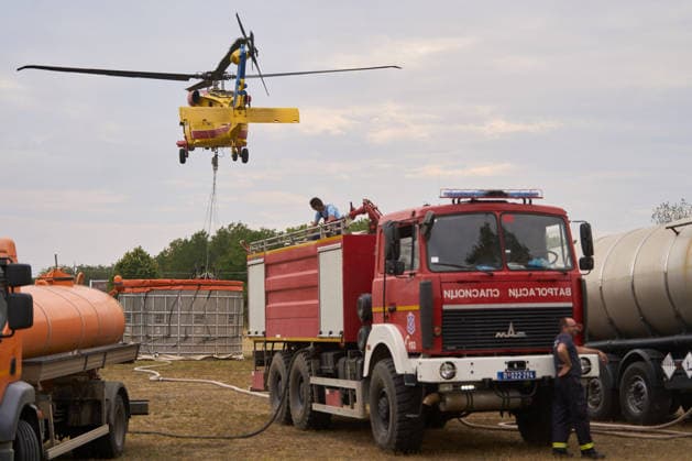 August 25, 2026, Susara, Vojvodina, Serbia: 2026825, Susara, Serbia - Two Sikorsky UH-60 Black Hawk helicopters are deployed to the village of Susara to help battle the severe wildfires devastating the Deliblato Sands (Deliblatska Pescara) Special Nature Reserve, refilling their buckets from a large portable water tank placed on a local football pitch. Susara Serbia - ZUMAd223 20260825_zip_d223_005 Copyright: xMarkoxDimicx