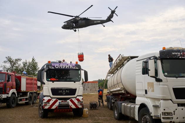 August 25, 2026, Susara, Vojvodina, Serbia: 2026825, Susara, Serbia - Two Sikorsky UH-60 Black Hawk helicopters are deployed to the village of Susara to help battle the severe wildfires devastating the Deliblato Sands (Deliblatska Pescara) Special Nature Reserve, refilling their buckets from a large portable water tank placed on a local football pitch. Susara Serbia  - ZUMAd223 20260825_zip_d223_010 Copyright: xMarkoxDimicx