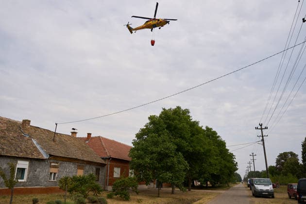 August 25, 2026, Susara, Vojvodina, Serbia: 2026825, Susara, Serbia - Two Sikorsky UH-60 Black Hawk helicopters are deployed to the village of Susara to help battle the severe wildfires devastating the Deliblato Sands (Deliblatska Pescara) Special Nature Reserve, refilling their buckets from a large portable water tank placed on a local football pitch. Susara Serbia  - ZUMAd223 20260825_zip_d223_012 Copyright: xMarkoxDimicx