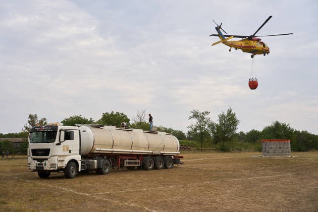 August 25, 2026, Susara, Vojvodina, Serbia: 2026825, Susara, Serbia - Two Sikorsky UH-60 Black Hawk helicopters are deployed to the village of Susara to help battle the severe wildfires devastating the Deliblato Sands (Deliblatska Pescara) Special Nature Reserve, refilling their buckets from a large portable water tank placed on a local football pitch. Susara Serbia - ZUMAd223 20260825_zip_d223_011 Copyright: xMarkoxDimicx
