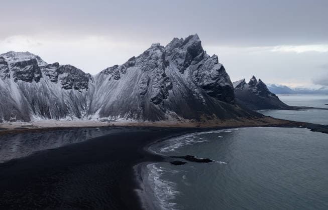 Der Berg Vestrahorn mit Blick auf den schwarzen Sandstrand von Stokksnes, Island Vestrahorn mountain stands above the black sand beach and ocean waves at stokksnes. Iceland landscape (License=RF) Copyright: xZoonar.com MichalakisxPpalisx 25457251
