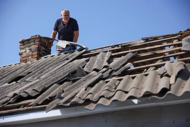 RUSSIA, LUGANSK - AUGUST 26, 2026: A man is seen on the roof of a residential house damaged following a strike by the Armed Forces of Ukraine. Alexander Reka TASS  96655042