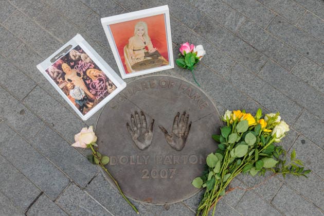 Dolly Parton tribute, Wembley Park, UK Wembley Park, London, UK. 26th August 2026. Flowers and photos are being left beside Dolly Parton s hand prints in the Square of Fame outside the OVO Arena Wembley in tribute to the country music legend who died aged 80 yesterday. One framed photo shows the late singer alongside her handprint cast., Credit:Photo by Amanda Rose Amanda Rose Avalon United Kingdom, Middlesex, Wembley Park, Arena Square  Copyright: xPhotoxbyxAmandaxRosex xAmandaxRosex xAvalonx 1128613911