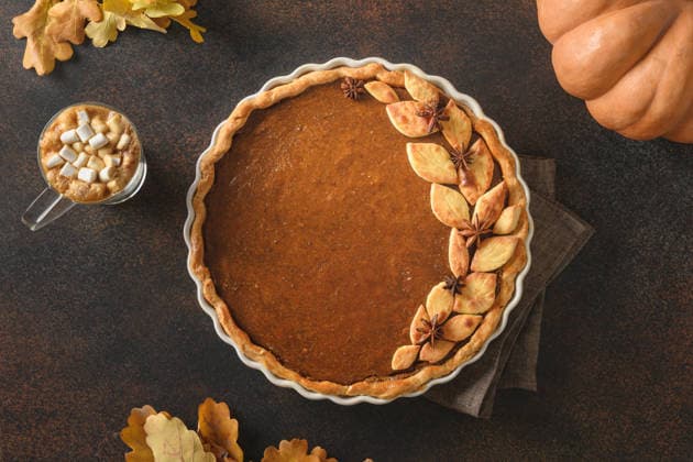 Leckerer, selbstgebackener Kürbiskuchen mit einem wärmenden Kaffee zum Erntedankfest. Homemade seasonal tasty pumpkin pie with warming coffee for Thanksgiving Day on brown background. View from above. (License=RF) Copyright: xZoonar.com SvetlanaxLazhkox 25461451