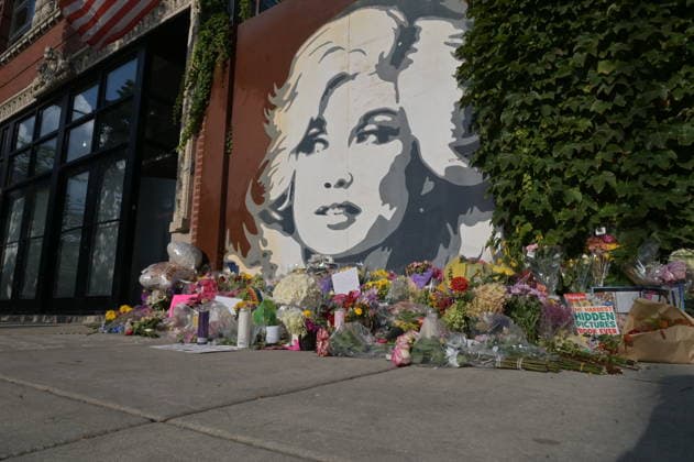 Flowers and candles left by Dolly Parton mural in Chicago CHICAGO, ILLINOIS, UNITED STATES - AUGUST 26: A view of flower bouquets, handwritten notes, and candles left by mourners at the base of the iconic Dolly Parton mural outside The Lytle House event venue in the Edgewater neighborhood in Chicago, Illinois, United States, on August 26, 2026. Fans and members of the community have transformed the local landmark into a growing memorial site to pay their respects following the passing of the country music legend, actress, and philanthropist at age 80. Jacek Boczarski Anadolu Illinois United States. Editorial use only. Please get in touch for any other usage. Copyright: x2026xAnadoluxJacekxBoczarskix