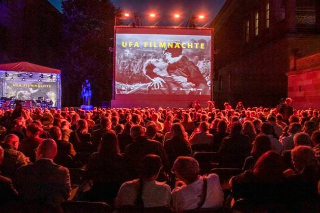 ABB FILMNACHT- Uebersicht mit Film Leinwand Gaeste Besucher beim Eroeffnungsempfang zu den UFA Filmnaechten 2026 auf der Dachterrasse der Bertelsmann Repraesentanz am 26.AUGUST 2026 in Berlin Berlin Deutschland