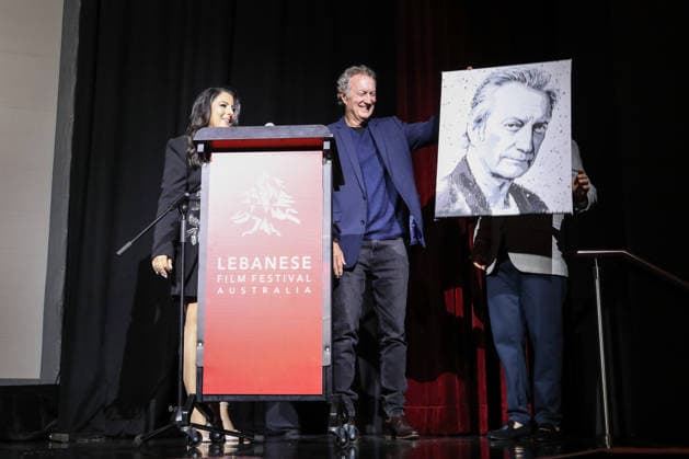 August 27, 2026: BRYAN BROWN C) receives a self portrait gift at the Lebanese Film Festival Australia 2026 Opening Night at the Bryan Brown Theatre on August 27, 2026 in Sydney, NSW Australia  - ZUMAa155 20260827_aaa_a155_073 Copyright: xChristopherxKhouryx