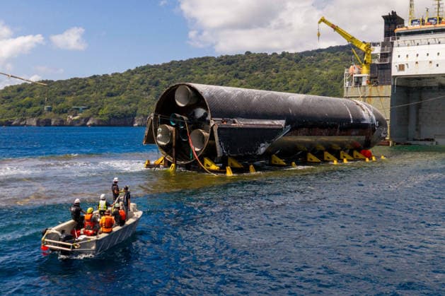 SpaceX engineers spent several days inspecting Ship 40 in the waters off Christmas Island as seen in pictures released on Thursday, August 27, 2026. They collected heatshield samples and gained vital insight into how the vehicle handled reentry, with improvements now planned for future vehicles. Starship has now been loaded onto a semi-submersible ship to begin the several-month journey back to Starbase.  WAX2026082707 SPACEX