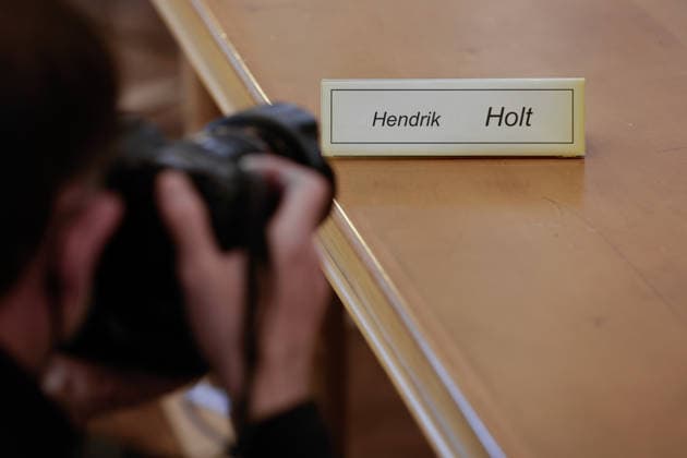 Windkraftbetrüger Hendrik Holt Ein Pressefotograf lichtet am 12.05.2022 vor der Urteilsverkündung der 2. Großen Strafkammer im Schwurgerichtssaal des Landgerichts Osnabrück (Niedersachsen, Deutschland) das Namensschild von Windkraftbetrüger Hendrik Holt ab. Holt wurde wegen banden- und gewerbsmäßigen Betrugs, Bestechung und Urkundenfälschung zu einer mehrjährigen Haftstrafe verurteilt; aktuell wird nach ihm gefahndet, nachdem er am 25. August 2026 nach einem genehmigten unbegleiteten Ausgang nicht in die Justizvollzugsanstalt zurückkehrte.