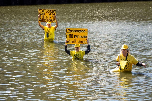 September 1, 2026, The Hague, South Holland, The Netherlands Holland: Protesters standing in the water of the Hofvijver hold signs reading State support for Tata is throwing money in the water (L) and Ã¢öÂ¬2000000000 = Ã¢öÂ¬110 per resident. Do you pay? (R) (translated from Dutch). On September 1, 2026, in The Hague, Netherlands, Extinction Rebellion activists protested the Dutch governmentÃ¢â‚¬â ¢s plan to subsidize Tata Steel with 2 billion euros to make its operations more sustainable. They held banners in the water of the Hofvijver, a man-made pond adjacent to the Dutch parliament. The Hague The Netherlands Holland - ZUMAp202 20260901_zip_p202_003 Copyright: xJamesxPetermeierx