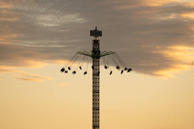 Das Kirmes-Karussell Aeronaut ist beim Glücksgefühle Festival auf dem Hockenheimring im Abendlicht als Silhouette zu sehen. Hockenheim Baden-Württemberg Deutschland