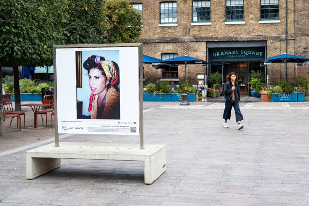 September 9, 2026, London, United Kingdom: A woman seen walking past a portrait of Amy Winehouse displayed as part of the ˜Amy Winehouse. Visitors view ˜Amy Winehouse: In Focus™, a free outdoor photography exhibition at Granary Square and King™s Boulevard in King™s Cross, London. The exhibition features defining and previously unseen photographs of the late singer, offering an intimate portrait of her life and career and marking 20 years since the release of her acclaimed album ˜Back to Black™. The exhibition runs from 1 September to 15 October 2026. London United Kingdom - ZUMAs197 20260909_aaa_s197_583 Copyright: xJamesxWilloughbyx