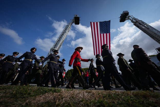 September 11, 2026, Surrey, Bc, CANADA: An RCMP officer in red serge marches with Canada Border Services Agency officers as a U.S. flag flies from ladders on fire trucks, during the Northwest 9 11 Memorial ceremony at the Peach Arch monument on the Canada-U.S. border between Surrey, B.C., and Blaine, Wash., in Surrey, B.C., on Friday, Sept. 11, 2026. Surrey CANADA - ZUMAc35_ 20260911_zaf_c35_102 Copyright: xDarrylxDyckx