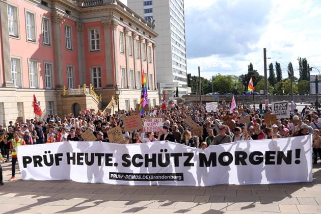 Demonstranten laufen mit Banner Prüf heute. Schütz morgen! um den Landtag während einer Demonstration für die Überprüfung rechtsextremer Parteien durch das Bundesverfassungsgericht, Alter Markt, Potsdam, 12. September 2026. Prüf-Demo in Potsdam