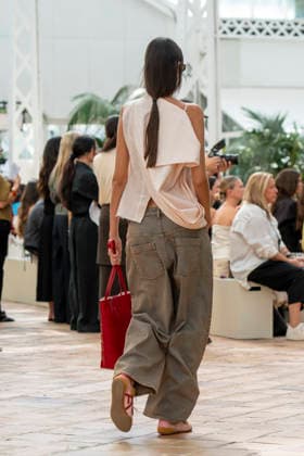 Models present creations from Adolfo Dominguez s Croma collection for spring-summer 2027 during Mercedes-Benz Fashion Week Madrid. Under the creative direction of Tiziana Domínguez, the Galician label, marking its 50th anniversary, remained faithful to its signature codes, showing pronounced asymmetry, scarves worked into both menswear and womenswear, sequins and textile appliques, alongside organic cotton denim dyed in tangerine tones and mini-pleated men s trousers. September 14,2026. (20260914844)