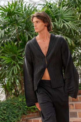 Models present creations from Adolfo Dominguez s Croma collection for spring-summer 2027 during Mercedes-Benz Fashion Week Madrid. Under the creative direction of Tiziana Domínguez, the Galician label, marking its 50th anniversary, remained faithful to its signature codes, showing pronounced asymmetry, scarves worked into both menswear and womenswear, sequins and textile appliques, alongside organic cotton denim dyed in tangerine tones and mini-pleated men s trousers. September 14,2026. (20260914970)