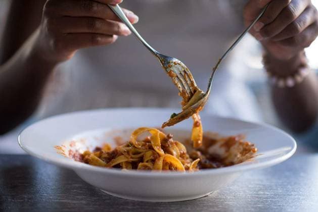 young beautiful African American woman enjoys while eating delicious pasta model released Symbolfoto Copyright: xdotshockx Panthermedia81509154.jpg