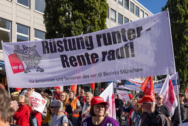 DGB Bayern - Hart verdient! Groß-Kundgebung, Nürnberg, 26.09.2026 Teilnehmende der Seniorinnen und Senioren des ver.di Bezirks München tragen ein Transparent mit der Aufschrift Rüstung runter - Rente rauf! durch die Menschenmenge. Umstehende Demonstrierende halten weitere Fahnen und Plakate, Nürnberg Bayern Deutschland