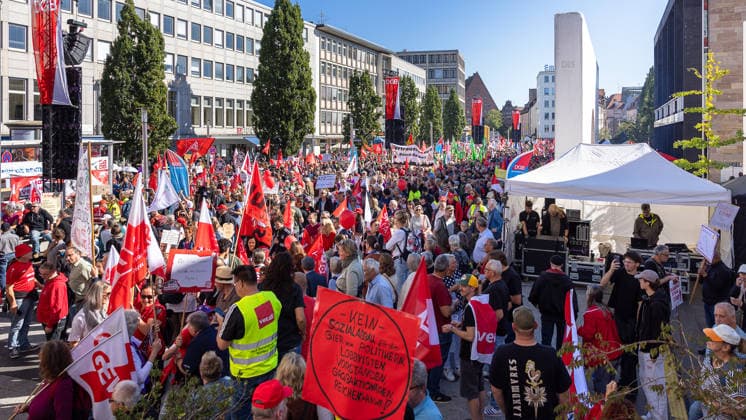DGB Bayern - Hart verdient! Groß-Kundgebung, Nürnberg, 26.09.2026 Am Kornmarkt versammeln sich zahlreiche Teilnehmer der DGB-Kundgebung Hart verdient! zu einem Protest mit Fahnen und Transparenten der Gewerkschaften. Ein Redner spricht von einer überdachten Bühne aus zur Menge, während Demonstranten Plakate mit Botschaften gegen soziale Ungerechtigkeit hochhalten. Nürnberg Bayern Deutschland