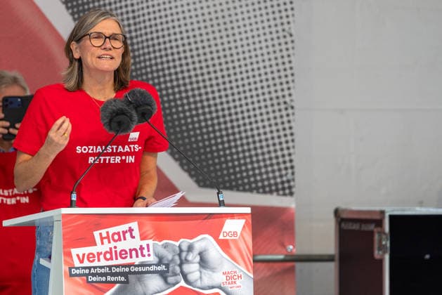 DGB Bayern - Hart verdient! Groß-Kundgebung, Nürnberg, 26.09.2026 Christiane Benner, Erste Vorsitzende der IG Metall, spricht mit ausdrucksstarker Gestik am Rednerpult bei einer Kundgebung des DGB. Sie trägt ein rotes T-Shirt mit der Aufschrift Sozialstaats-Retter*in und wirkt engagiert und entschlossen bei ihrer Rede. Nürnberg Bayern Deutschland
