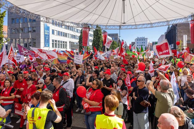 DGB Bayern - Hart verdient! Groß-Kundgebung, Nürnberg, 26.09.2026 Zahlreiche Teilnehmerinnen und Teilnehmer versammeln sich am Kornmarkt zu einer Kundgebung des DGB Bayern unter dem Motto Hart verdient! . Die Menge schwenkt Fahnen von ver.di und weiteren Gewerkschaften, mehrere Personen tragen rote Warnwesten und Shirts, andere applaudieren mit erhobenen Händen. Nürnberg Bayern Deutschland