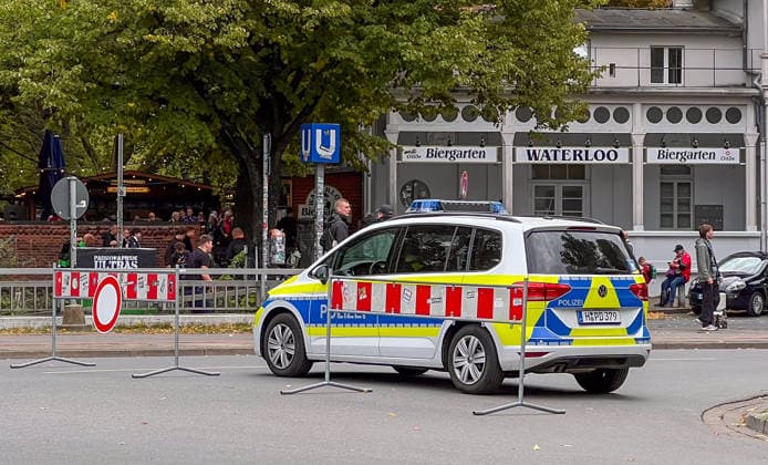 Hannover, Niedersachsen, Deutschland, Europa. Ein Einsatzfahrzeug der Polizei sichert den Bereich am Waterloo während einer Fußballveranstaltung. Absperrgitter, Besucher und Fans befinden sich im Hintergrund vor dem Waterloo Biergarten. Symbolbild für Polizeieinsatz, Sicherheitsmaßnahmen, Fußballfans, öffentliche Sicherheit und Veranstaltungsmanagement. Copyright: xAymanxAlahmedx