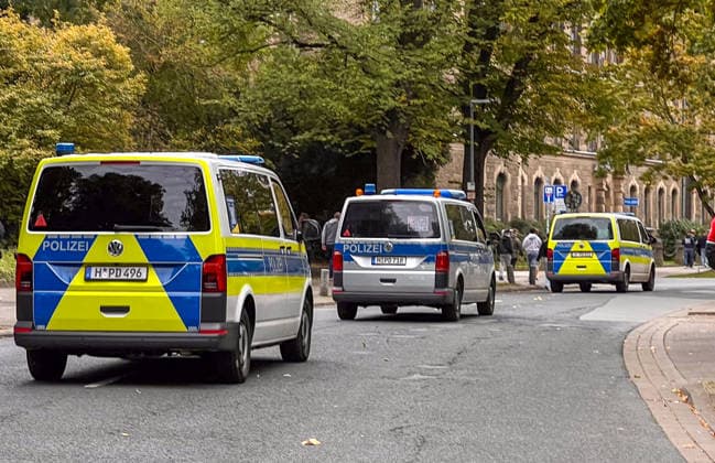 Hannover, Niedersachsen, Deutschland, Europa. Mehrere Einsatzfahrzeuge der Polizei sichern den Bereich rund um eine Fußballveranstaltung. Polizeitransporter stehen entlang der Straße, während sich Besucher und Fans im Hintergrund bewegen. Symbolbild für Sicherheitskonzept, Polizeipräsenz, Einsatzkräfte, öffentliche Ordnung und Großveranstaltungen. Copyright: xAymanxAlahmedx