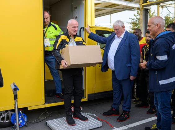 Niederlassungsleiter Ingo Kutsch l. trägt ein Paket mit einem Gewicht von 31 Kg, daneben Minister Laumann. Thema Gewichtsbegrenzung bei Paketen. Arbeitsminister Karl-Josef Laumann (CDU, NRW) besucht die Post- und Paketzustellbasis in Düsseldorf, am 28.09.2026 in Düsseldorf Deutschland.