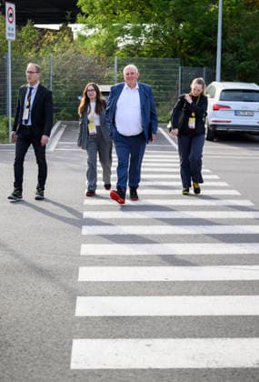 Minister Laumann kommt zu Fuss mit seinem Team zu dem Termin, trögt Arbeitssicherheitsschuhe. geht über einen Zebrastreifen, Fussgängerüberweg. Arbeitsminister Karl-Josef Laumann (CDU, NRW) besucht die Post- und Paketzustellbasis in Düsseldorf, am 28.09.2026 in Düsseldorf Deutschland.