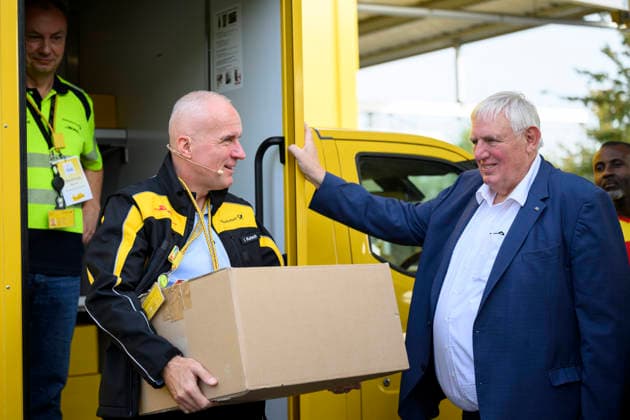 Niederlassungsleiter Ingo Kutsch trägt ein Paket mit 31 KG Gewicht, daneben Minister Laumann. Thema Gewichtsbegrenzung bei Paketen. Arbeitsminister Karl-Josef Laumann (CDU, NRW) besucht die Post- und Paketzustellbasis in Düsseldorf, am 28.09.2026 in Düsseldorf Deutschland.
