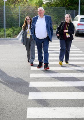 Minister Laumann kommt zu Fuss mit seinem Team zu dem Termin, trögt Arbeitssicherheitsschuhe. geht über einen Zebrastreifen, Fussgängerüberweg. Arbeitsminister Karl-Josef Laumann (CDU, NRW) besucht die Post- und Paketzustellbasis in Düsseldorf, am 28.09.2026 in Düsseldorf Deutschland.