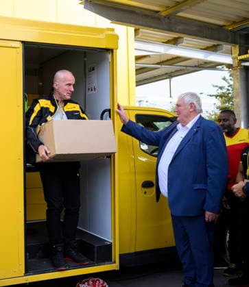 Niederlassungsleiter Ingo Kutsch l. trägt ein Paket mit einem Gewicht von 31 Kg, daneben Minister Laumann. Thema Gewichtsbegrenzung bei Paketen. Arbeitsminister Karl-Josef Laumann (CDU, NRW) besucht die Post- und Paketzustellbasis in Düsseldorf, am 28.09.2026 in Düsseldorf Deutschland.