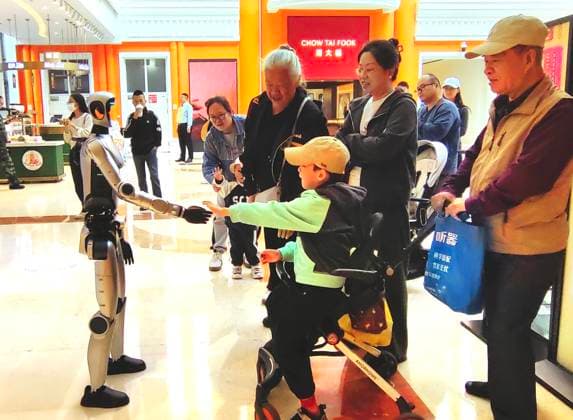 HARBIN, CHINA - JANUARY 29: An AI robot shakes hands with children at a shopping mall on January 29, 2025 in Harbin, Heilongjiang Province of China. The humanoid robot, capable of gestures such as waving and making heart shapes as well as voice communication, was seen moving through the mall and interacting with customers.  Copyright: xVCGx 111670495812