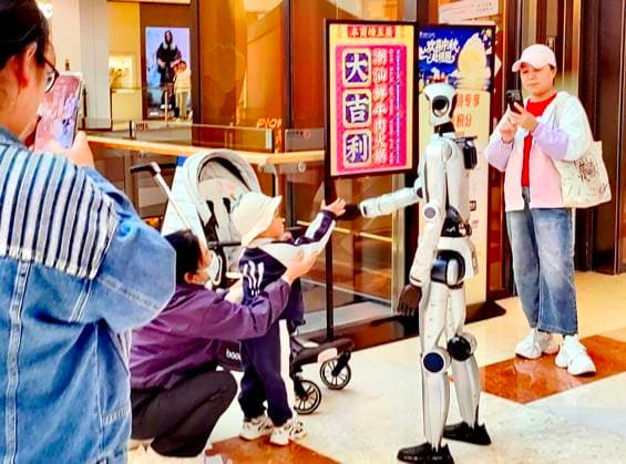 HARBIN, CHINA - SEPTEMBER 29: A humanoid robot interacts with customers at a shopping mall on September 29, 2026 in Harbin, Heilongjiang Province of China. The robot features flexible limb movements and can perform actions such as dancing, shaking hands, waving, and making heart gestures, as well as engaging in voice communication with people.  Copyright: xVCGx 111670495817