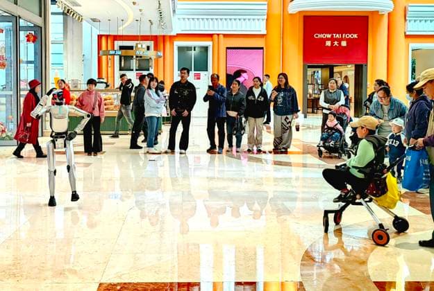 HARBIN, CHINA - SEPTEMBER 29: A humanoid robot interacts with customers at a shopping mall on September 29, 2026 in Harbin, Heilongjiang Province of China. The robot features flexible limb movements capable of dancing, shaking hands, waving, making heart gestures and engaging in voice communication with people.  Copyright: xVCGx 111670495818